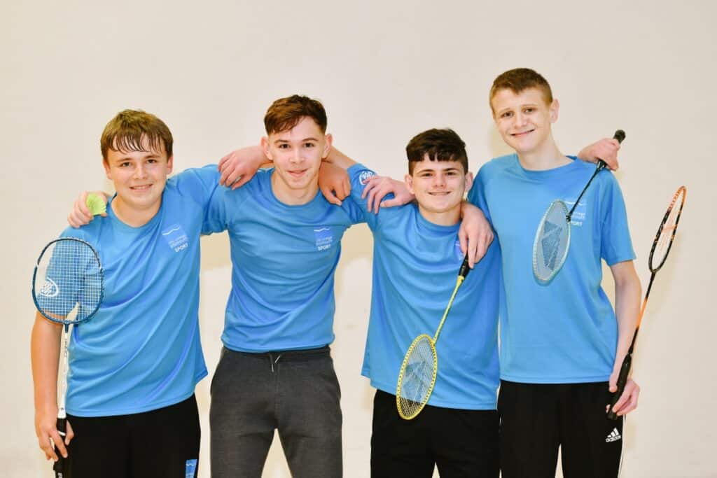 Four students pose after a game of badminton